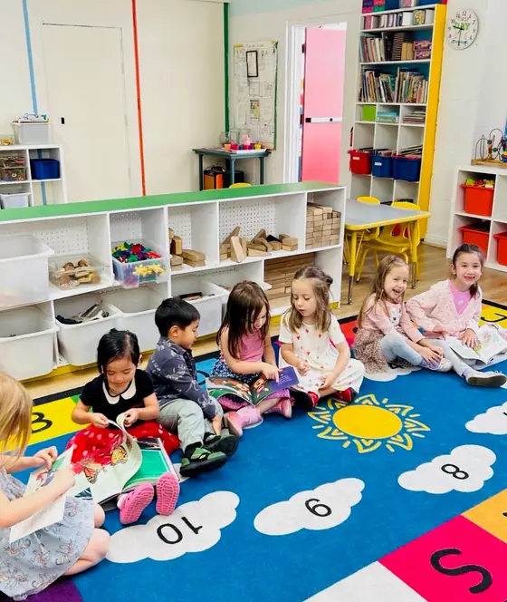 Children reading picture books together on the classroom rug