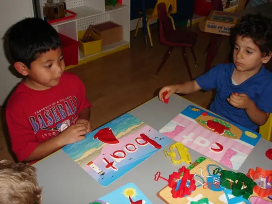Two boys pressing play dough onto picture and word cards