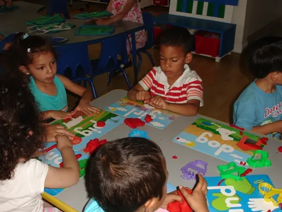 Children working with play dough and word cards at a table